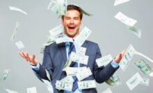 uomo felice in mezzo a tante banconote