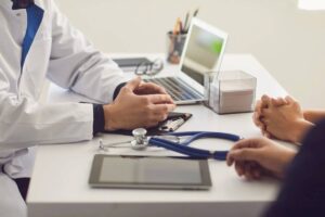 Medico seduto alla scrivania con paziente