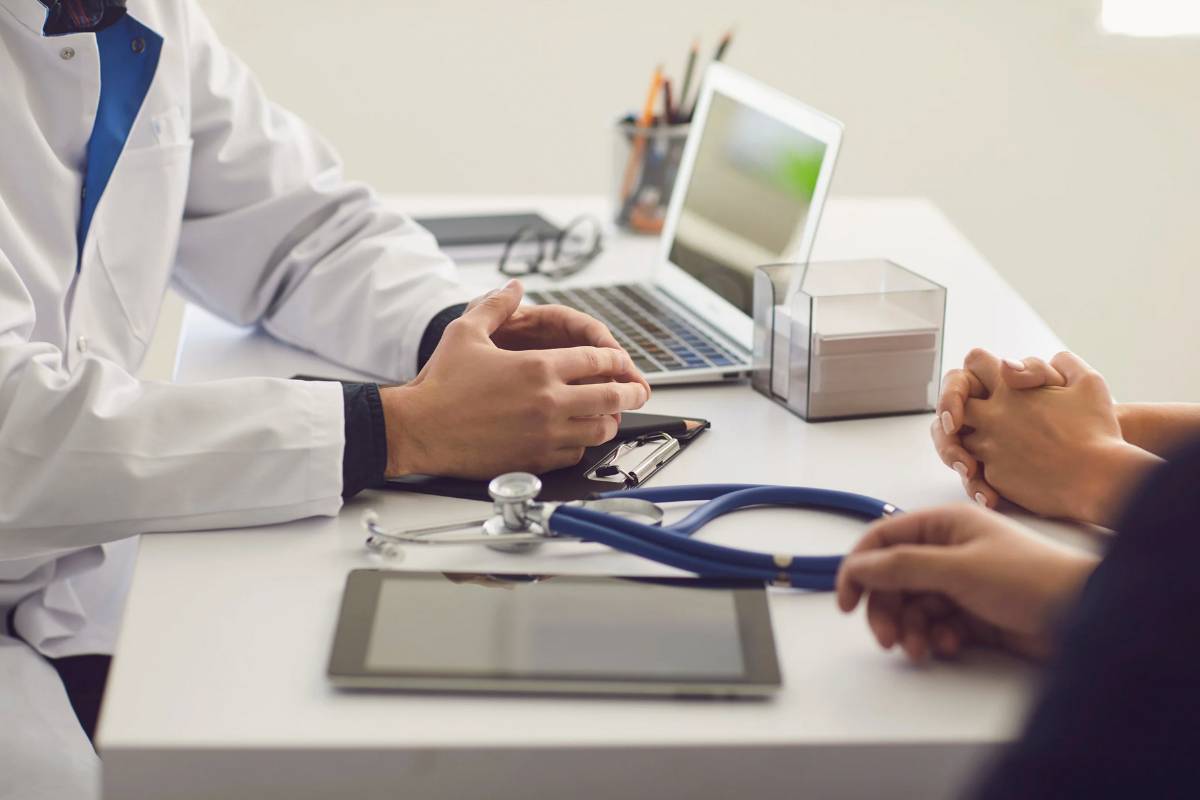 Medico seduto alla scrivania con paziente