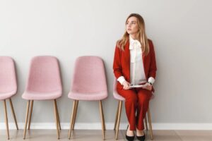 Donna co completo rosso seduta su una sedia