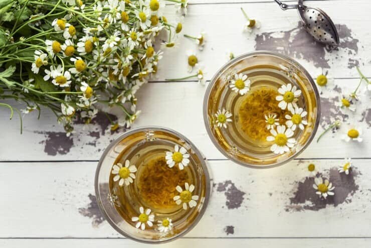 Bicchieri di tisana alla camomilla con fiori in infusione