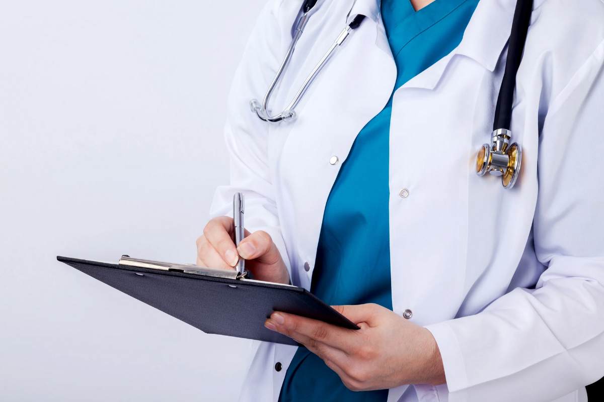 Medico che scrive su una cartellina
