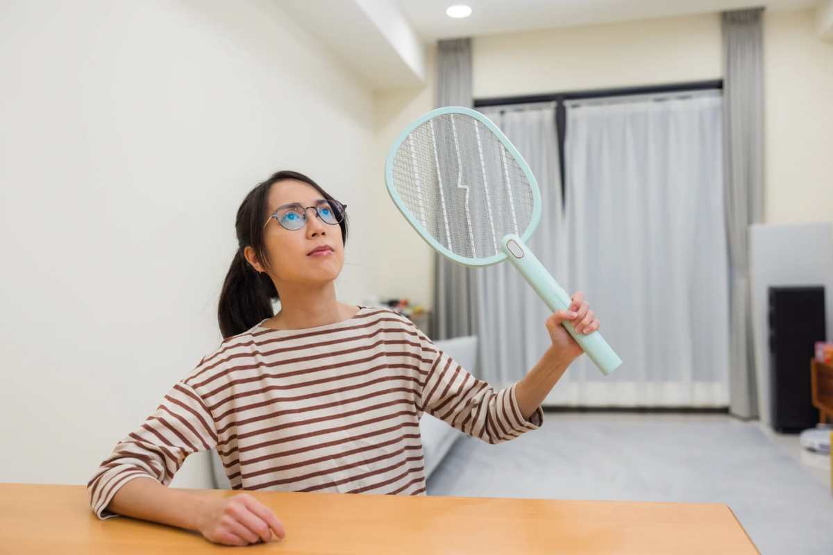 Donna con racchetta contro zanzare