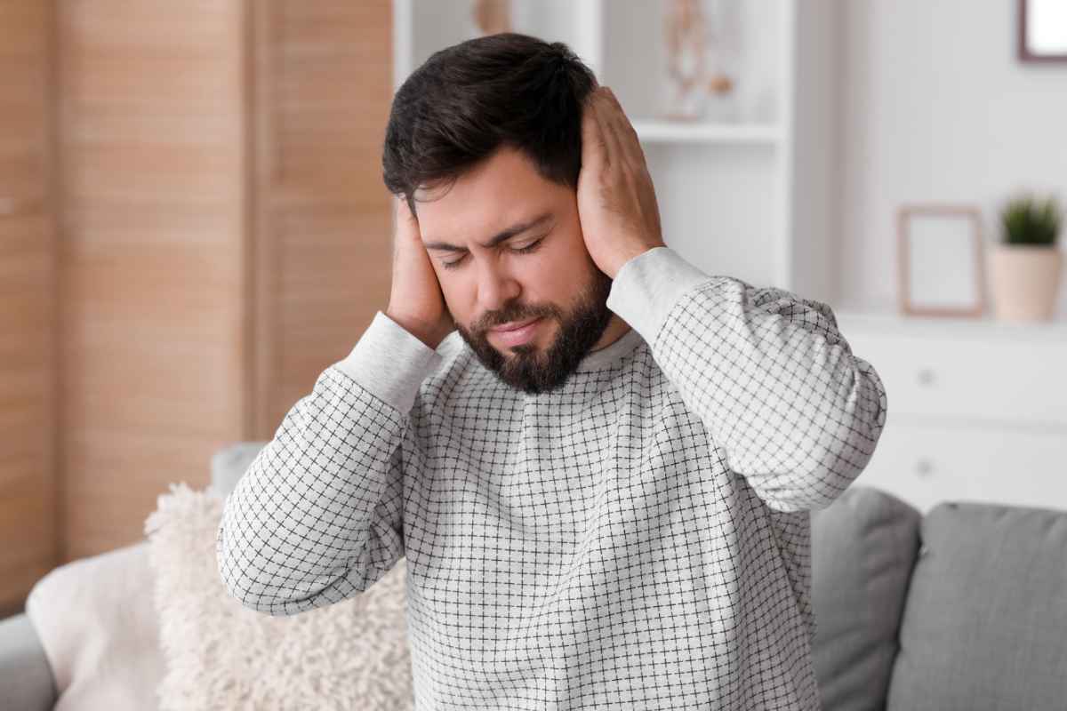 Uomo con mani sulle orecchie