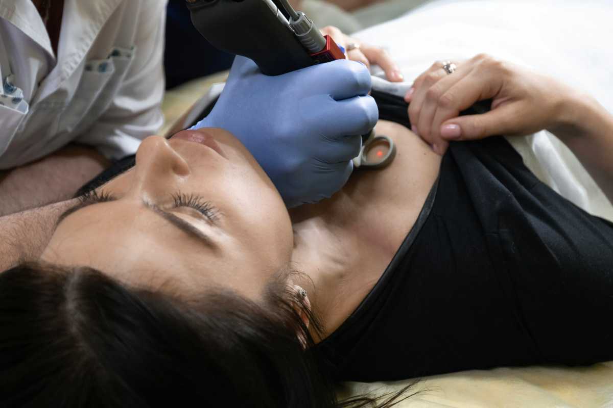 Visita medica: un dottore punta un laser sul petto di una paziente