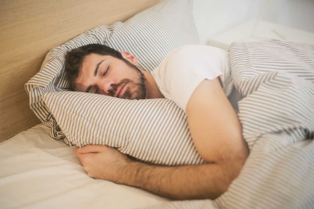 Uomo che dorme nel letto