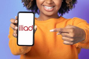 Ragazza con smartphone in mano e Iliad sullo schermo