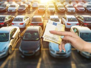sfondo parcheggio auto e banconota 200 euro in mano