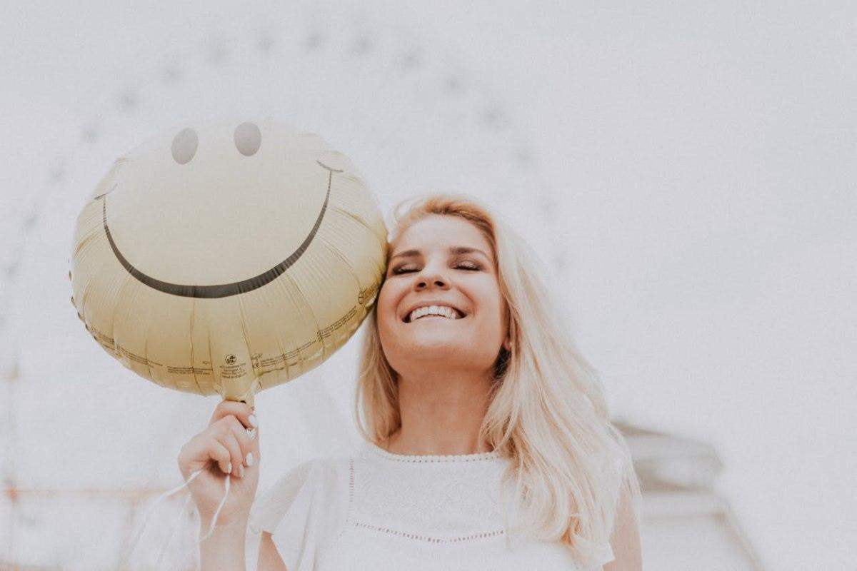 Donna sorridente che tiene in mano un palloncino