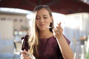 Donna che mangia con forchetta in mano