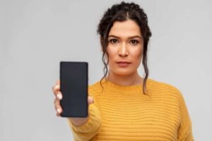 Donna vestita di giallo con cellulare in mano
