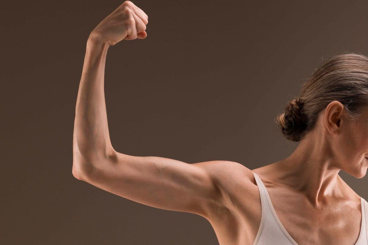 Donna mostra muscolo del braccio