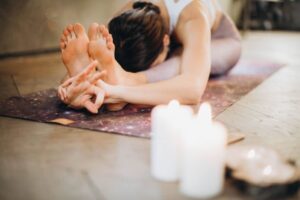 Donna fa stretching sul tappetino, candele