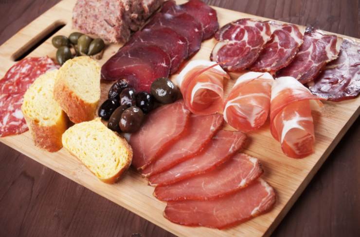 tagliere di salumi con delle fette di pane e delle olive
