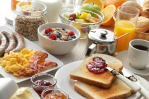 tavola abbondante per la colazione con uova, frutta, succhi, marmellate