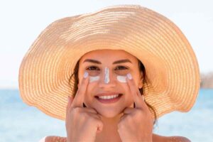 Donna che applica crema solare sul viso