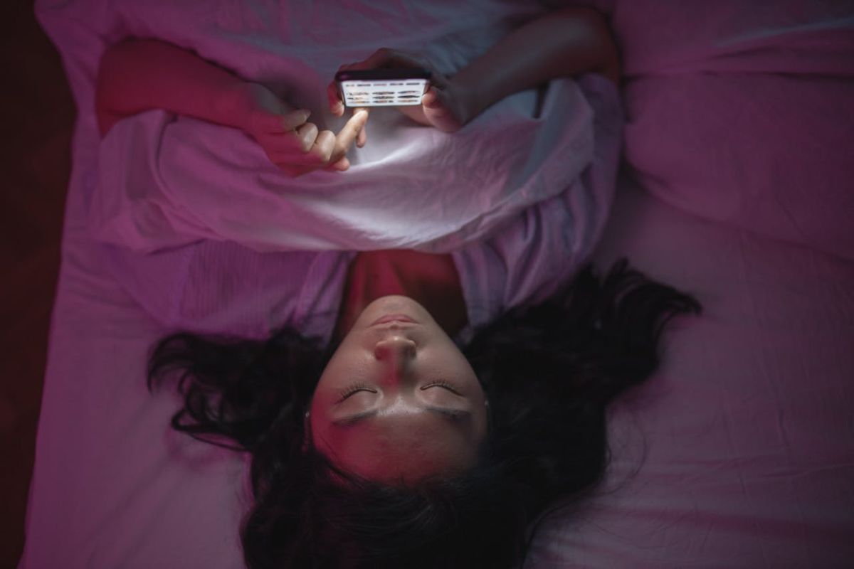 Ragazza che dorme con lo smartphone vicino