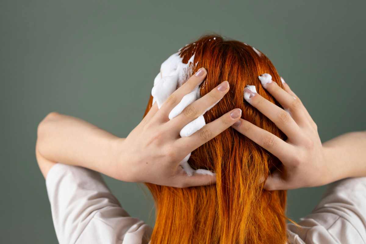 Donna con i capelli rossi che usa lo shampoo