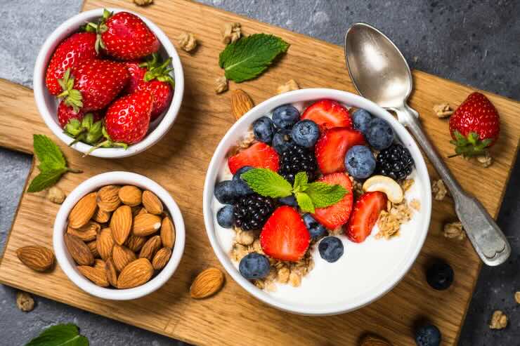 scodella di yogurt con frutta, fragole, mandorle