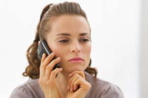 Donna con il telefono all'orecchio ed espressione seria