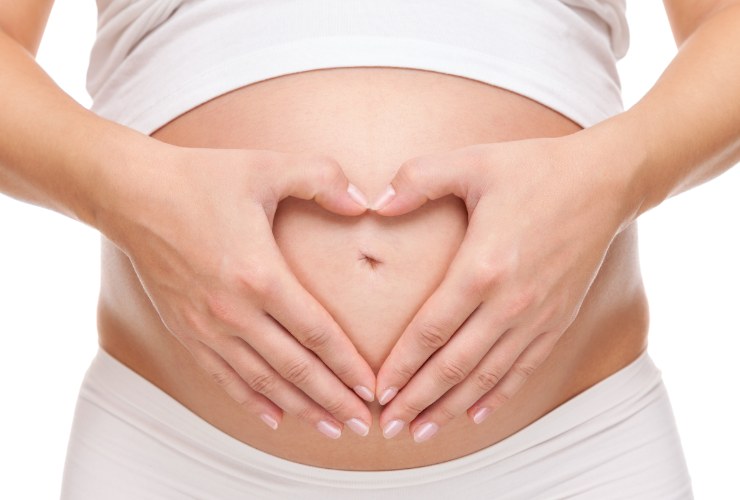mani a forma di cuore sul ventre