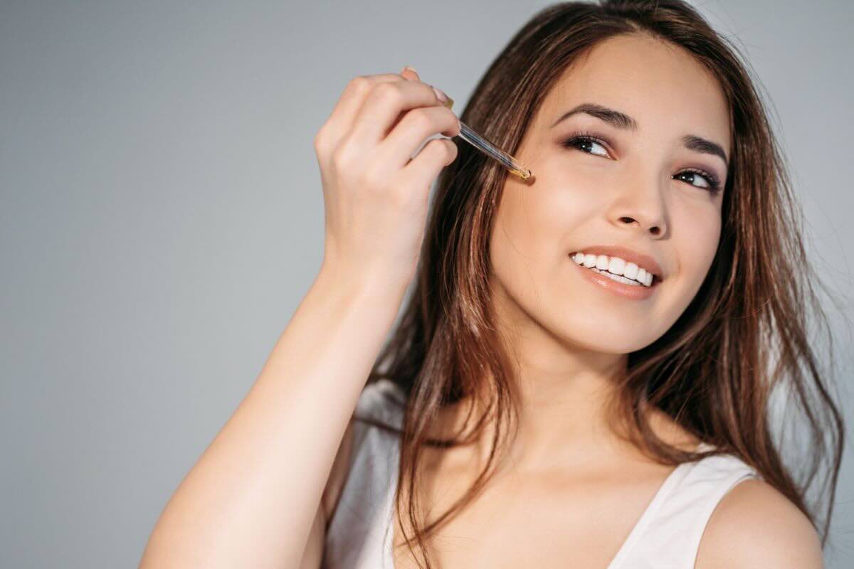 Donna applica olio sul viso