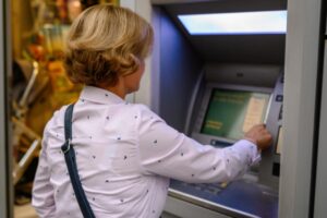 donna che preleva allo sportello automatico