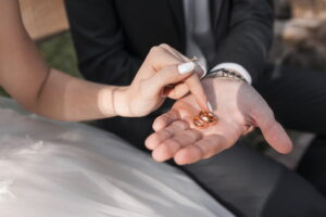 Sposa e sposo che toccano un paio di anelli d'oro