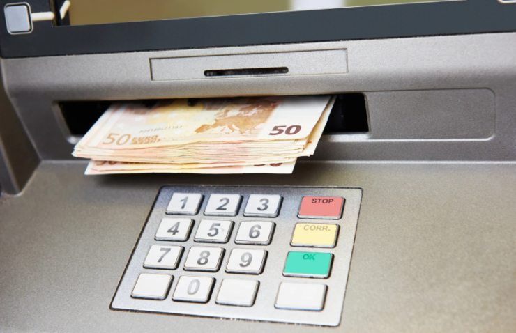 banconote che escono da uno sportello automatico