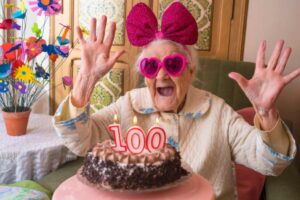 donna che festeggia i 100 anni con la torta di compleanno