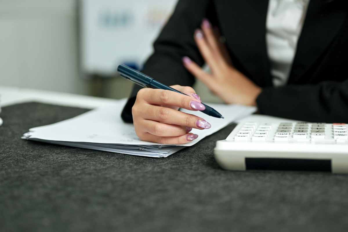 una mano con la penna e la calcolatrice fa i conti