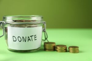 barattolo di vetro con scritto donazione e monetine