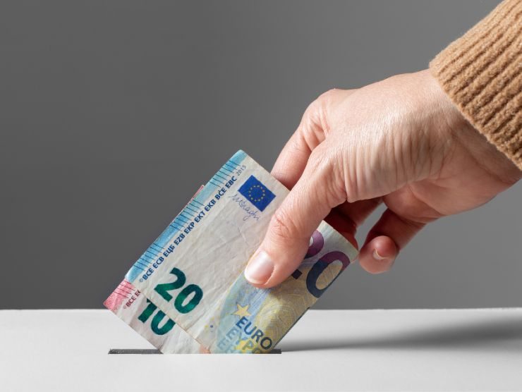 persona che inserisce soldi in una fessura