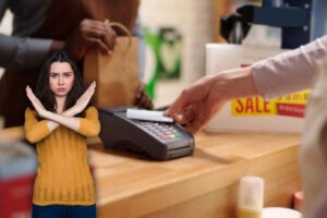 donna alla cassa che paga con carta e un'altra che fa stop con le braccia