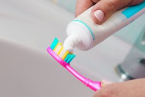 donna che mette dentifricio sullo spazzolino da denti